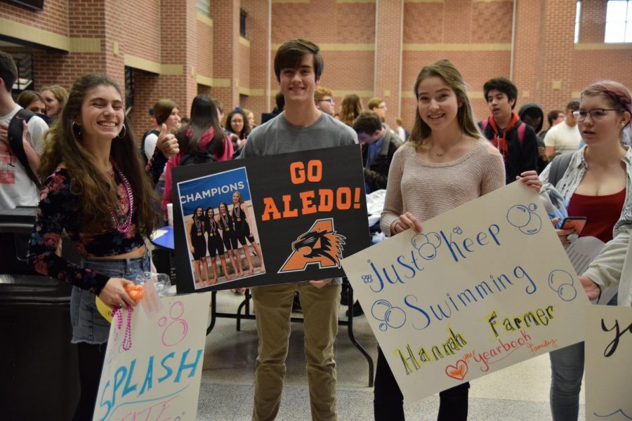 Pepper Purpera (Senior), Richard Farmer (Junior), and Samantha Allen (Sophomore) pose with their state swim send off posters.