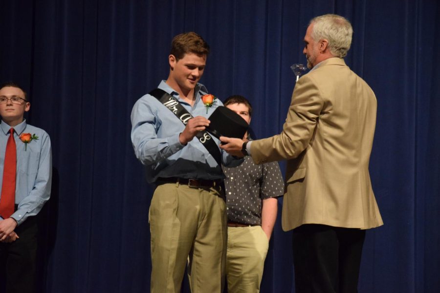 Zachary Reinert, the Mr. AHS winner is presented the scepter by Principal Dan Peterson. 