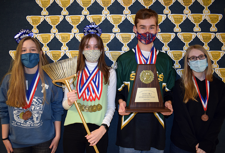 The UIL Journalism Team (right to left) senior Lydia Wood, senior Olivia Caggiano, senior James Ward and freshman Cassidy Cole pose outside the journalism room with their first place trophy.