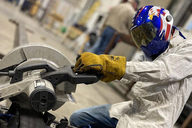 Junior Corbin Haber uses a circular saw to cut through steel. 