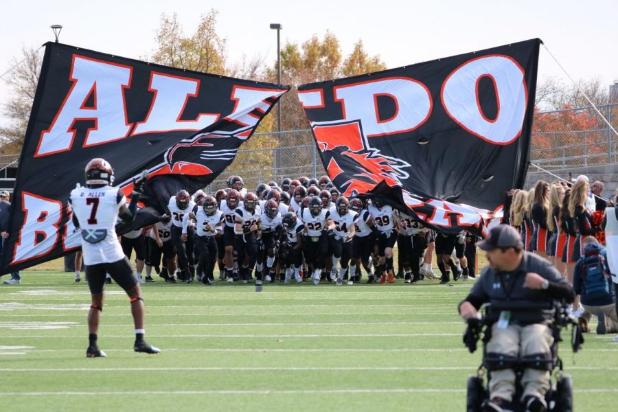 The varsity football team runs on the field before their playoff game against South Oak Cliff on Nov. 26.