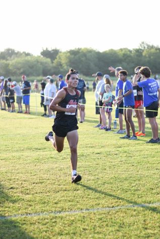 Senior Isaac Hernandez runs to the finish line after an exhausting race. 