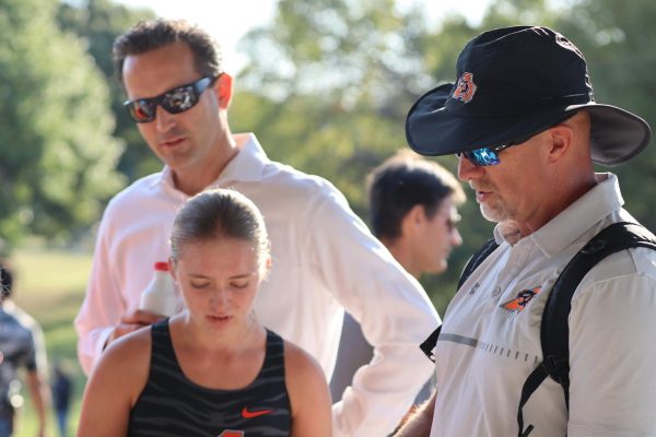 After the girls cross country team completed their races, head coach Michael Pinkerton meets with the athletes before the boys cross country team begins their meet at the district meet in White Settlement's Central Park, Saturday, Oct. 11. 