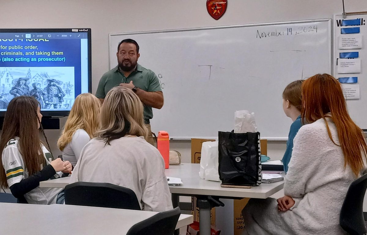 Listening to the Law
To learn about the history of law enforcement, junior Hailee Scroggins and Madeline Burns, senior Asyln Beyers, sophomore Audrey Kilton, and freshman Kate Cravery listen to law enforcement teacher Sgt. Juan Flores Thursday, Nov. 14 during first period.
"At my table especially, it’s fun because there’s one representative from each grade so that’s pretty cool," Byers said. 
