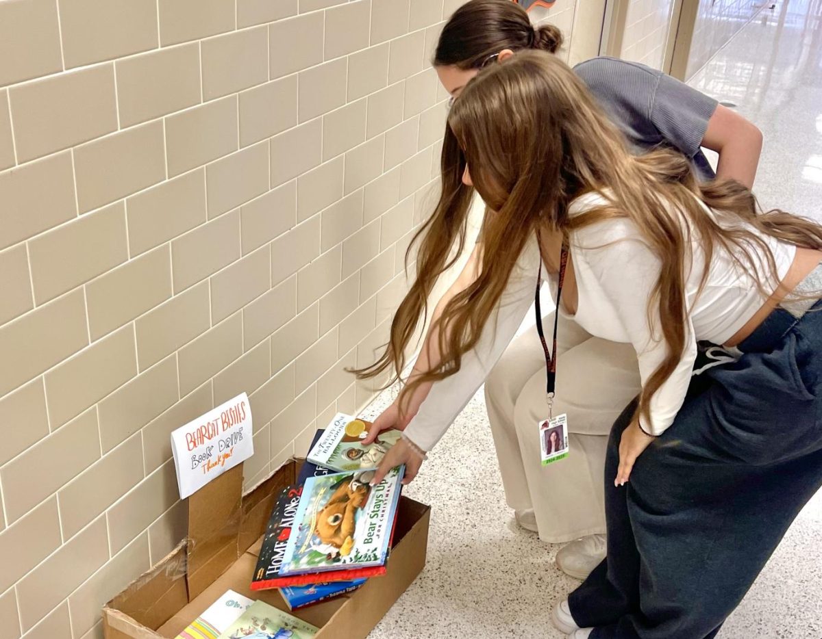 Stacking their books into box, Bearcat Besties members donate to Pythian Book Drive.