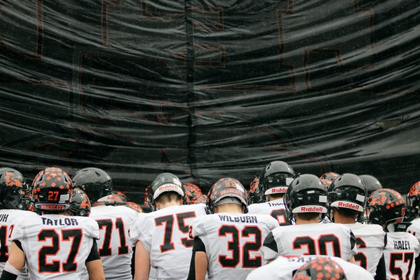 Seconds before the second half, the varsity football team hypes up before running through the banner. 